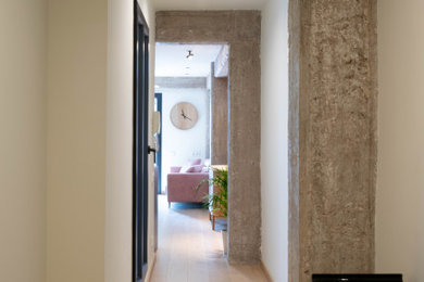 Imagen de recibidores y pasillos minimalistas de tamaño medio con paredes blancas, suelo de madera clara y suelo beige