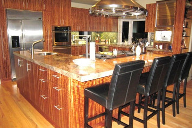 Foto på ett stort funkis kök med öppen planlösning, med släta luckor, granitbänkskiva, grönt stänkskydd, stänkskydd i keramik, rostfria vitvaror och mellanmörkt trägolv