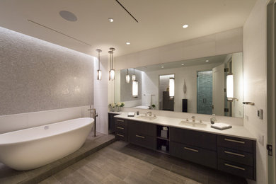 Example of a huge minimalist master gray tile freestanding bathtub design in Chicago with white walls