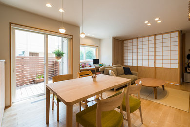 Photo of a mid-sized scandinavian open plan dining in Yokohama with light hardwood floors, no fireplace, brown floor and white walls.