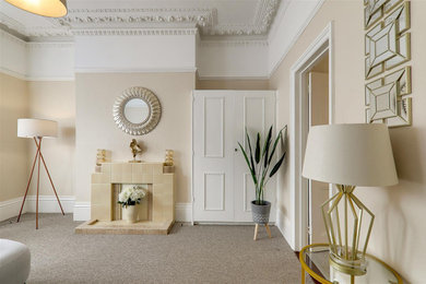 This is an example of a small traditional grey and cream living room in Sussex with beige walls, carpet, a tiled fireplace surround and beige floors.