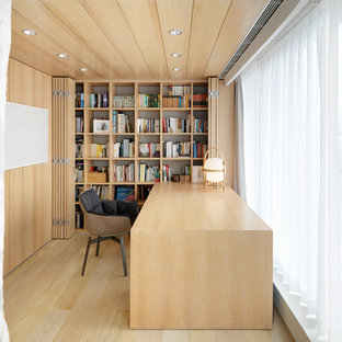 Design ideas for a medium sized world-inspired home office and library with light hardwood flooring and a built-in desk.
