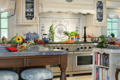 Elegant kitchen photo in New York with glass-front cabinets, white cabinets, porcelain backsplash, stainless steel appliances and two islands