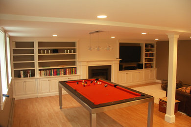 Example of a large transitional open concept light wood floor game room design in Boston with brown walls, a standard fireplace, a wood fireplace surround and a media wall