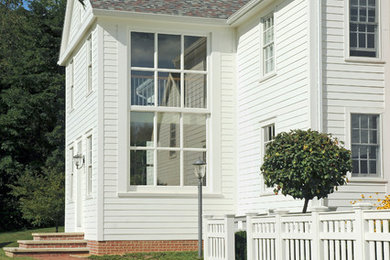 Inspiration for a mid-sized farmhouse white three-story wood gable roof remodel in Columbus