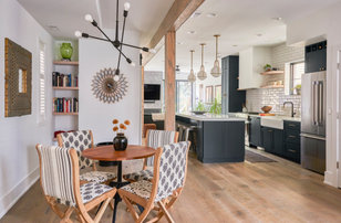 Photo of a large contemporary open plan dining in Chicago with white walls, medium hardwood floors, a hanging fireplace, a brick fireplace surround and planked wall panelling.