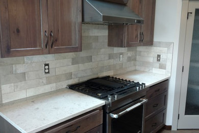 Large eclectic medium tone wood floor kitchen pantry photo in Seattle with an undermount sink, shaker cabinets, medium tone wood cabinets, quartz countertops, gray backsplash, ceramic backsplash, stainless steel appliances and an island