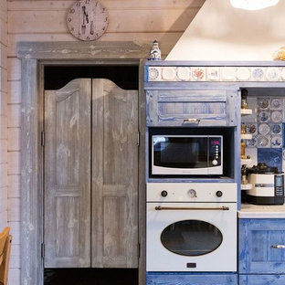 Large farmhouse kitchen pantry ideas - Inspiration for a large farmhouse l-shaped porcelain floor kitchen pantry remodel in Moscow with a drop-in sink, raised-panel cabinets, blue cabinets, wood countertops, blue backsplash, ceramic backsplash, white appliances and an island