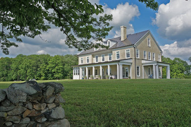 Example of a large cottage beige two-story exterior home design in DC Metro with a metal roof