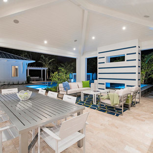 Inspiration for a large transitional backyard patio in Miami with an outdoor kitchen, tile and a roof extension.