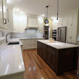 Inspiration för stora klassiska kök, med en undermonterad diskho, luckor med profilerade fronter, vita skåp, bänkskiva i kvarts, grått stänkskydd, stänkskydd i keramik, rostfria vitvaror, mörkt trägolv, en köksö och rött golv