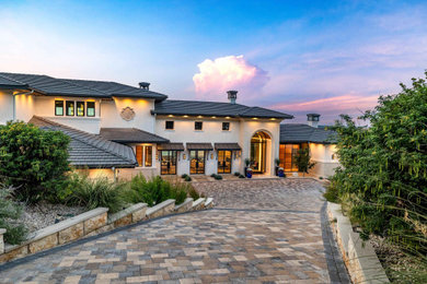 Huge mediterranean white two-story house exterior idea in Austin with a tile roof and a gray roof