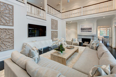 Photo of a large transitional formal open concept living room in New York with white walls, dark hardwood floors, a standard fireplace, a stone fireplace surround and a wall-mounted tv.