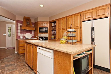 Inspiration for a l-shaped terra-cotta tile kitchen pantry remodel in Vancouver with a drop-in sink, raised-panel cabinets, light wood cabinets, quartz countertops, red backsplash, ceramic backsplash, white appliances and an island