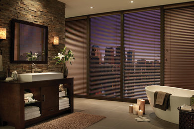 Example of a large transitional master brown tile and stone tile porcelain tile and brown floor freestanding bathtub design in New York with dark wood cabinets, flat-panel cabinets, multicolored walls, a vessel sink and wood countertops