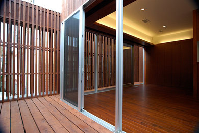 This is an example of a modern balcony in Tokyo with no cover and wood railing.
