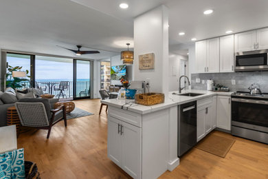 Kitchen - large coastal galley kitchen idea in Hawaii with shaker cabinets, white cabinets and an island