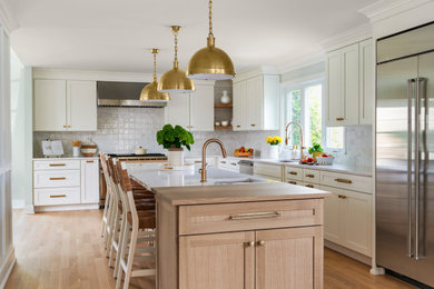 Large transitional l-shaped kitchen photo in New York with an undermount sink, shaker cabinets, quartz countertops, porcelain backsplash, stainless steel appliances and an island