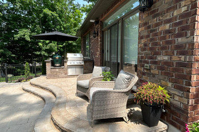 Idées déco pour une terrasse arrière classique de taille moyenne avec une cuisine d'été et des pavés en béton.