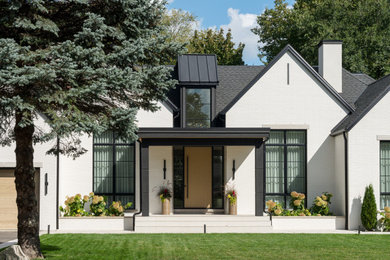 Large contemporary white one-story brick house exterior idea in Toronto with a shingle roof and a black roof