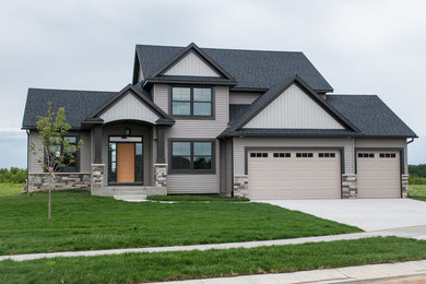 Large arts and crafts beige two-story mixed siding exterior home photo in Other with a shingle roof