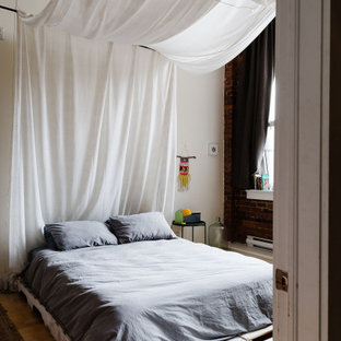 Großes Eklektisches Schlafzimmer im Loft-Style mit weißer Wandfarbe, hellem Holzboden und Ziegelwänden in Montreal
