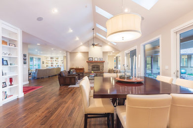 Example of a mid-sized transitional medium tone wood floor and brown floor great room design in Toronto with beige walls and no fireplace