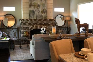 Example of a mid-sized classic open concept dark wood floor and brown floor living room design in Birmingham with beige walls, a standard fireplace, a brick fireplace and no tv