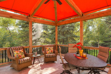 This is an example of a large transitional backyard deck in Minneapolis with an awning.