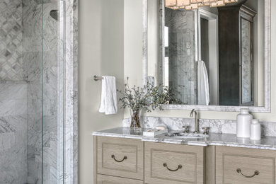 Example of a large trendy master marble tile marble floor and single-sink freestanding bathtub design in St Louis with light wood cabinets, gray walls, an undermount sink, marble countertops, a hinged shower door and a freestanding vanity