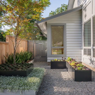 Réalisation d'un jardin avant minimaliste de taille moyenne et au printemps avec une exposition ensoleillée et des pavés en béton.