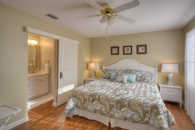 Photo of a mid-sized beach style master bedroom in Jacksonville with beige walls, medium hardwood floors, no fireplace and brown floor.