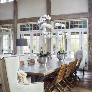 На фото: большая гостиная-столовая в стиле кантри с белыми стенами, паркетным полом среднего тона и коричневым полом без камина с