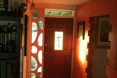 Inspiration for a mid-sized eclectic ceramic tile and beige floor entryway remodel in San Francisco with orange walls and a medium wood front door