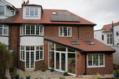 Design ideas for a medium sized and multi-coloured classic brick semi-detached house in Other with three floors, a pitched roof and a tiled roof.
