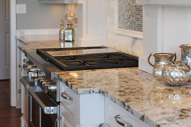 Mid-sized transitional l-shaped dark wood floor open concept kitchen photo in Other with an undermount sink, raised-panel cabinets, white cabinets, granite countertops, white backsplash, mosaic tile backsplash, stainless steel appliances and an island