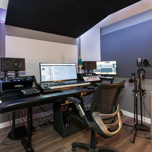 Photo of a small transitional home studio in Los Angeles with light hardwood floors, grey walls, a freestanding desk and brown floor.