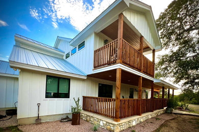 Mittelgroßes, Zweistöckiges Klassisches Einfamilienhaus mit Faserzement-Fassade, weißer Fassadenfarbe, Satteldach, Blechdach, weißem Dach und Wandpaneelen in Austin