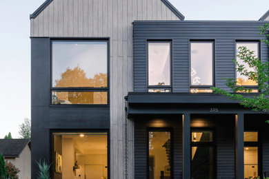 Ejemplo de fachada de casa pareada marrón y negra escandinava de tamaño medio de tres plantas con revestimientos combinados, tejado a dos aguas y tejado de metal