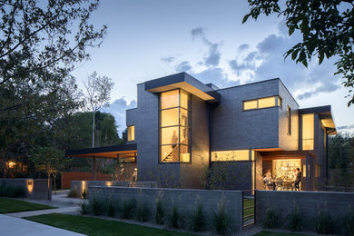 Inspiration for a modern black two-story brick flat roof remodel in Denver