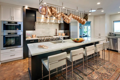 Example of a large transitional l-shaped medium tone wood floor enclosed kitchen design in Los Angeles with an undermount sink, white cabinets, quartzite countertops, gray backsplash, stone slab backsplash, stainless steel appliances, an island and shaker cabinets