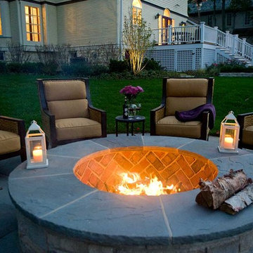 Closeup of stone fire pit with outdoor wing back chairs