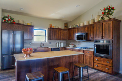 Mid-sized transitional l-shaped laminate floor and gray floor eat-in kitchen photo in St Louis with a farmhouse sink, shaker cabinets, medium tone wood cabinets, quartz countertops, beige backsplash, ceramic backsplash, black appliances, an island and beige countertops