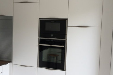 Imagen de cocina actual de tamaño medio con fregadero bajoencimera y electrodomésticos con paneles