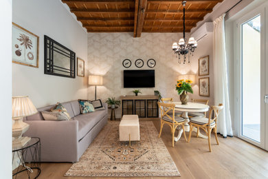 Modelo de salón abierto actual pequeño con paredes beige, suelo de madera clara, televisor colgado en la pared, casetón y papel pintado