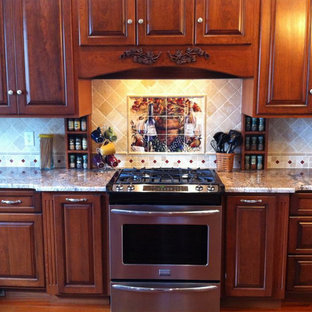 Mid-sized kitchen pantry designs - Example of a mid-sized l-shaped kitchen pantry design in Huntington with raised-panel cabinets, medium tone wood cabinets, soapstone countertops and stone tile backsplash