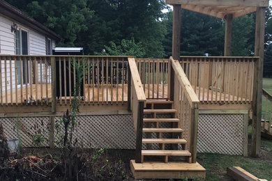 Example of a mid-sized backyard deck design in Cincinnati with a pergola