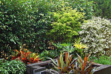 Inspiration for a small tropical backyard shaded formal garden for summer in Hong Kong with a water feature and natural stone pavers.