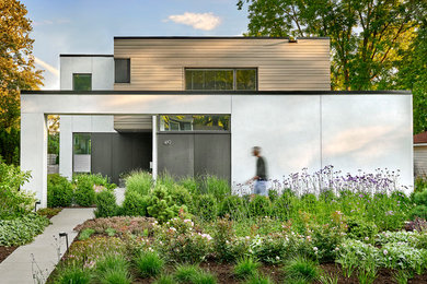 Mid-sized modern two-storey black house exterior in Chicago with concrete fiberboard siding and a flat roof.