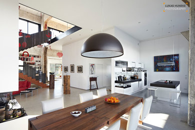 Großes Industrial Wohnzimmer mit weißer Wandfarbe und Betonboden in Sonstige